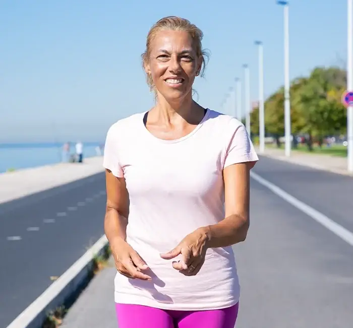 A woman walking briskly along a seafront path